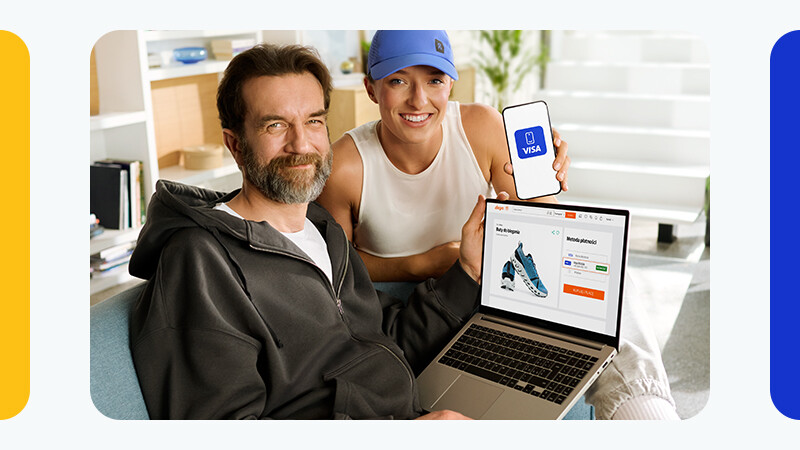 2 people smiling with laptop and visa card on phone