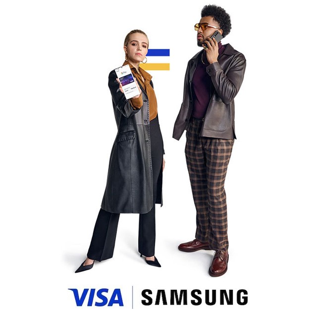 couple holding mobiles above visa samsung logo
