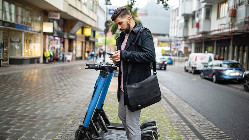 man next to electric scooter