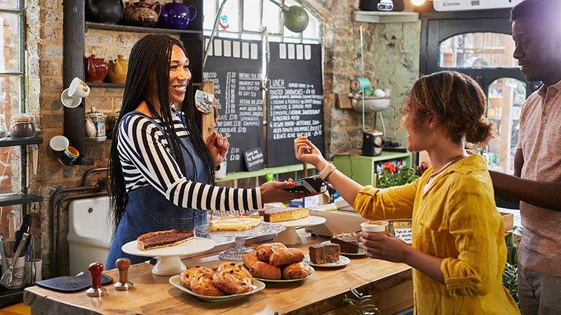 woman making contactless watch payment in shop